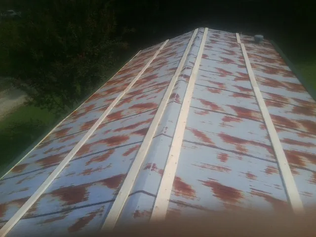 Rusted metal roof panels with new wood purlins before replacement — Storm Damage Roof Repair in Stantonville by Roofing Brothers