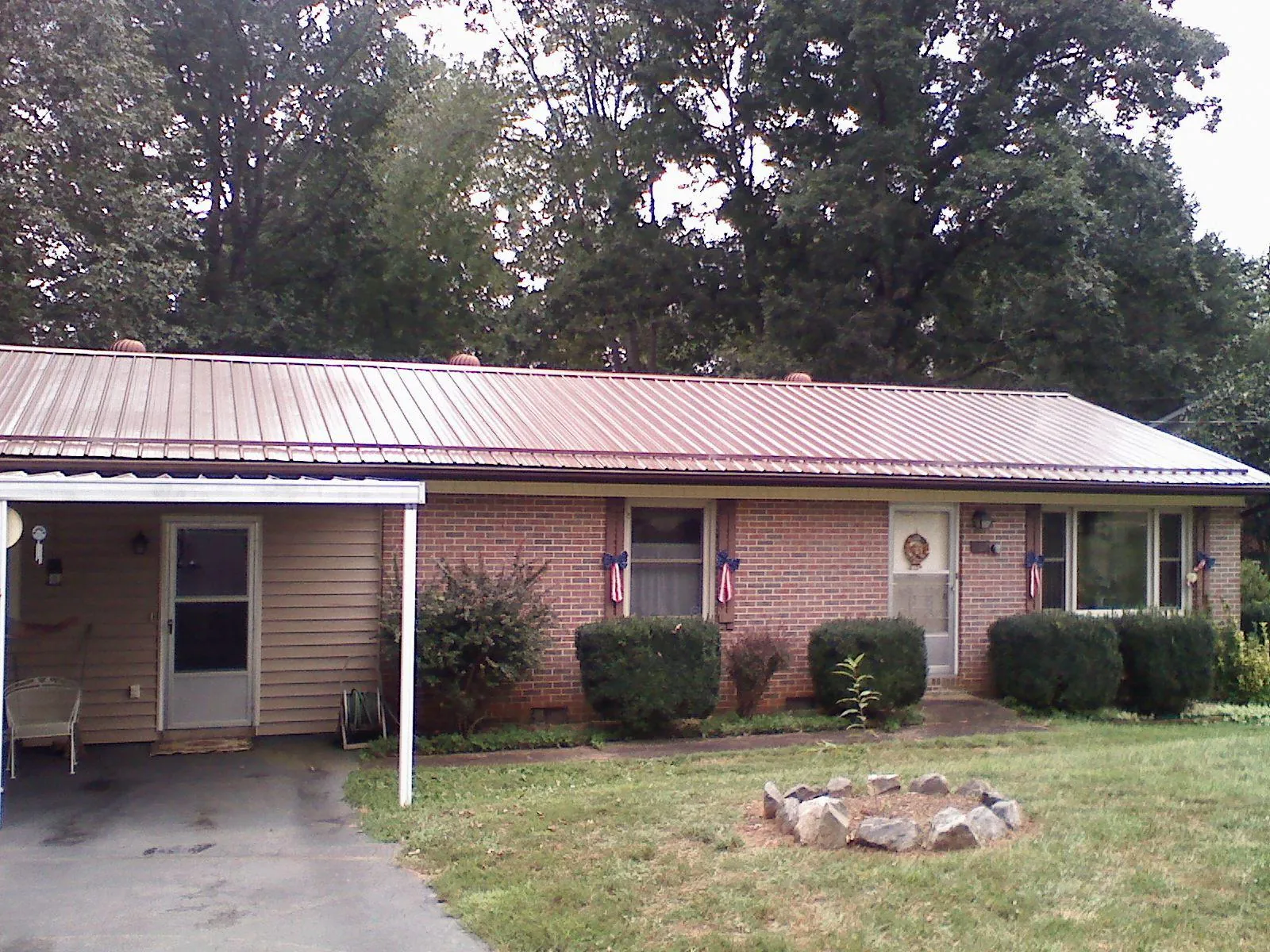 Bronze metal roof and carport on a brick ranch home — Roof Repair work by our crew in Stantonville